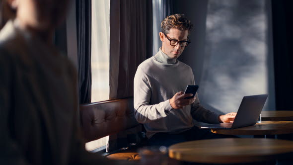 Ung man som sitter framför sin laptop och skriver.